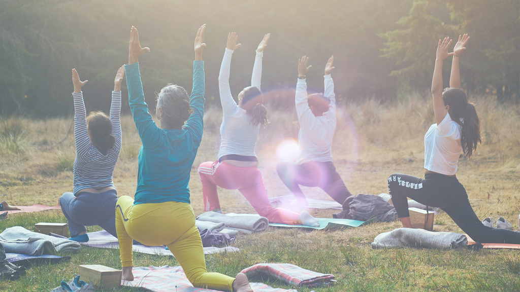 Eine Personengruppe bei der Yogapraxis im Freien.